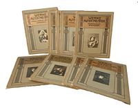 Nine vintage beige paperback art books with decorative framed cover images and titles in German, arranged standing and lying down
