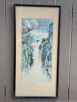 Full view of the framed vintage Chinese waterfall landscape print showing the entire artwork and frame mounted on a vertical wooden surface.