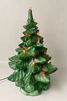 Front view of vintage ceramic Christmas tree with multicolored lights illuminated and green glossy finish.