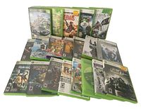 Twenty Xbox 360 game cases spread out showing different game titles including Halo, Assassin's Creed IV Black Flag, Rainbow Six Vegas 2, and Fallout 3.