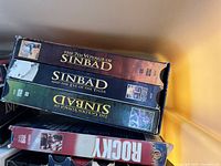 Photo showing three VHS tapes from the Sinbad series and one Rocky tape with visible wear.