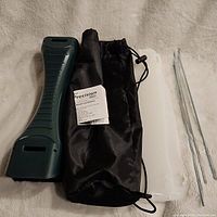 Chronograph accessories and carrying case including black drawstring bag, instruction manual, white plastic holder, and metal rods