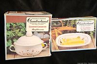 Photo of both original boxes showing Cumberland stoneware items: Covered Casserole 2 quart and 10" Oval Baker in Mayblossom pattern.