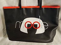 Front view of black faux leather tote bag with red trim and Edna Mode graphic on front showing overall condition and design details.