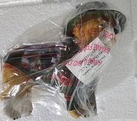 Front and side view of the Hamilton Collection U.S.M.C. dog figurine wrapped in plastic inside protective styrofoam.