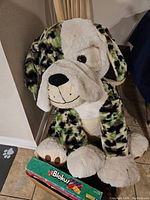 Large plush dog with camouflage pattern and foam toy guitar in front