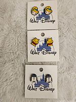 Front view of three pairs of Disney stud earrings on original Walt Disney branded backing card showing Cinderella, Winnie the Pooh, and R2-D2 characters.