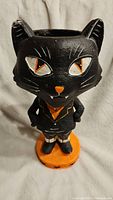 Front view of the black cat figurine showing eyes, nose, ears, and overall condition