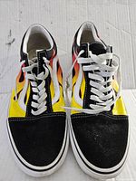 Front view of Vans Old Skool flame design sneaker pair with white laces and black suede toe caps.