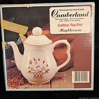Boxed Cumberland coffee/tea pot showing full front and top of pot with floral pattern and lid knob.