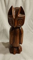 Front view of vintage hand carved wooden owl showing full body and detailed carving on head, wings and feet.