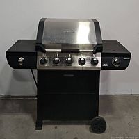 Front view of Brinkmann gas grill with closed lid, shows black body, stainless steel lid and control knobs