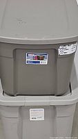 Stacked view of two beige/gray plastic storage bins, top one is Sterilite brand, bottom one is Brightroom brand.