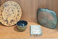 Overview of all four items: wood calendar plaque, glass bowl, Jewish hanging plaque, metal vase
