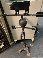 Full front view of entire weather vane, showing pig silhouette, arrow shaft, directionals and tripod base