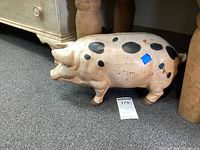 Side view of full figurine showing cream body, black spots and overall shape.