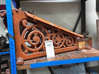 Full side view of the vintage Counterboy cast iron tape dispenser showing orange paint and scrollwork design.