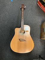 Full view of Kona acoustic guitar, natural wood finish, showing body, neck, headstock and strings.