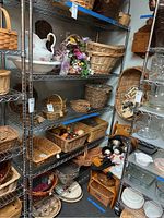 Full view of the metal shelving unit showing multiple wire shelves stocked with various baskets and other household items (contents not included in sale).