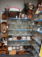 Full view of the 7-tier metal rolling shelf filled with various glassware and baskets, demonstrating shelving configuration and size.