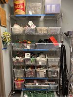 Front view of fully assembled 6-tier chrome wire shelf loaded with plastic bins