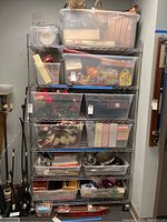 Full view of the 6-tier rolling NSF metal shelf loaded with various plastic storage bins and miscellaneous items.