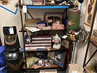 Photo of three shelves with various Americana and patriotic decor including word art signs, figurine, pillow, and framed photo.
