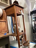Side angle view of primitive wooden stool showing drawer and lower shelf.