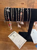 View of 9 sterling silver bracelets displayed on a black stand, showing different chain styles and clasps, most marked 925, some with tags indicating 925.