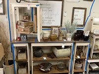 Overall view of lot showing one small accent table perched atop three matching shelving units.