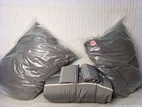 Bed cover and two king euro pillow covers wrapped in plastic, gray color with white and dark gray stripes on bed cover.