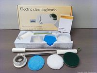 Top view of the set including multiple cleaning heads, extendable handle, and user manual.