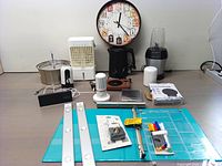 Photo showing entire kitchen stuff bundle with appliances, clocks, and organizational items arranged neatly on a table.