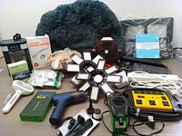 Full view of the bundle showing multiple items including surge protectors, vacuum, fans, lights, pest repellers, and pet bed.