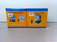 Two boxed search lights side by side showing packaging and model names Remote 360 and E120.