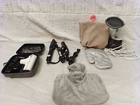 Full view of personal care items including massage tool in case, two hair stylers, garment steamer with glove, and hot water bottle pouch.