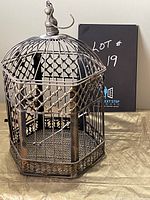 Front angled view of hexagonal metal birdcage showing lattice design and hanging hook.
