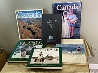 Shows entire set of six books arranged on a table, with focus on covers showing Canadian themes and lot label book in center