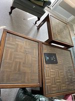 Three wood coffee tables with glass tops placed next to each other; visible crack in the glass of the largest table.
