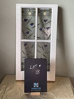 Front view of faux stained glass window panel, showing full white frame and floral decorative glass sections.