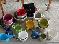 Photo showing a cluster of varied flower pots in different colors, shapes, and materials placed on carpet.