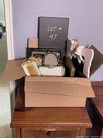 Box filled with multiple decorative frames in various shapes and sizes, mostly rectangular, some ornate and embellished.