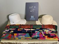 Photo showing two different women's hats (white narrow brim and beige wide brim) with four colorful scarves underneath them.