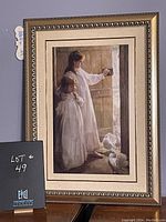 Framed print depicting two young girls in nightgowns standing at a door with white doves at their feet, in a decorative gold-toned frame.