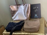 Photo showing the three purses: metallic rose gold tote, navy Calvin Klein bag, and Roots beige suede purse