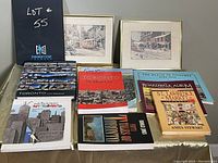 Wide shot of assorted Toronto books and two framed prints arranged on a flat surface.