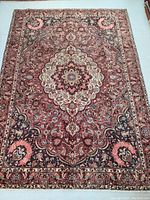 Full view of rug laid flat on floor showing overall pattern, colors and condition