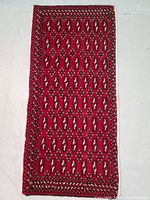 Top view of hand knotted Turkman wool rug showing full front surface with red, black, white, and brown geometric patterns.