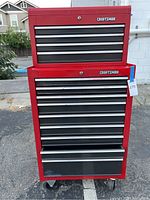 Front view of stacked red Craftsman toolboxes on asphalt surface