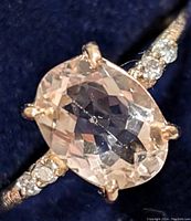 Close-up of oval morganite center stone and diamond-studded band